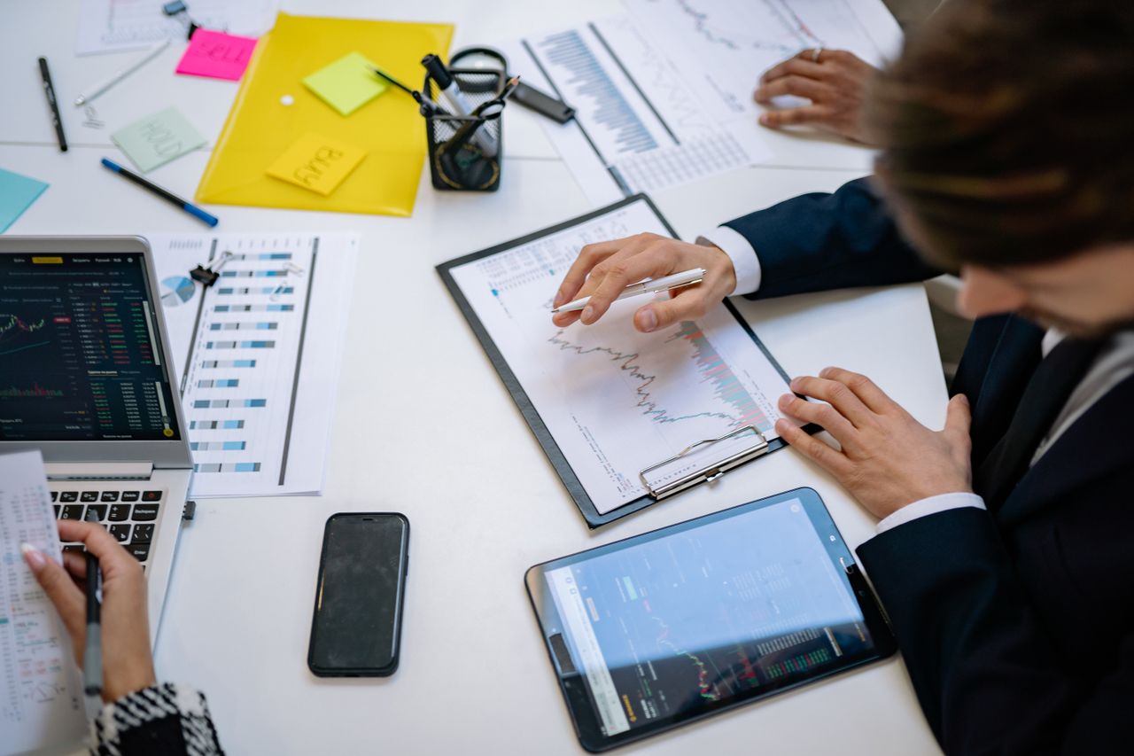 Une équipe passe en revue des graphiques financiers et des données numériques sur des tablettes dans un bureau.